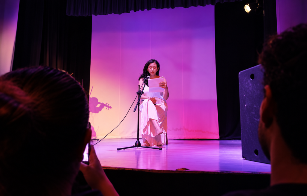 Participante realiza una lectura poética sobre el escenario durante la Tardeada Surrealista del Poeta Muerto en Cuautitlán Izcalli.