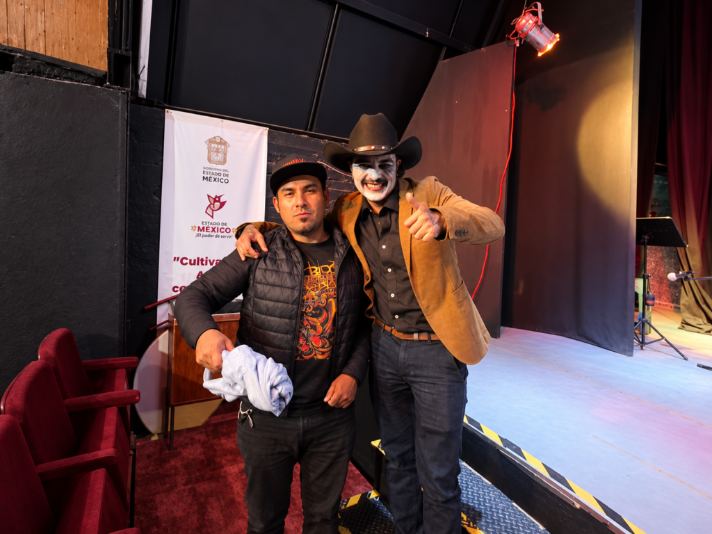 Dos participantes de la Tardeada Surrealista del Poeta Muerto posan junto al escenario del Centro Regional de Cultura de Cuautitlán Izcalli.